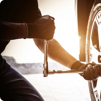 Homme inspectant les freins d'une voiture.