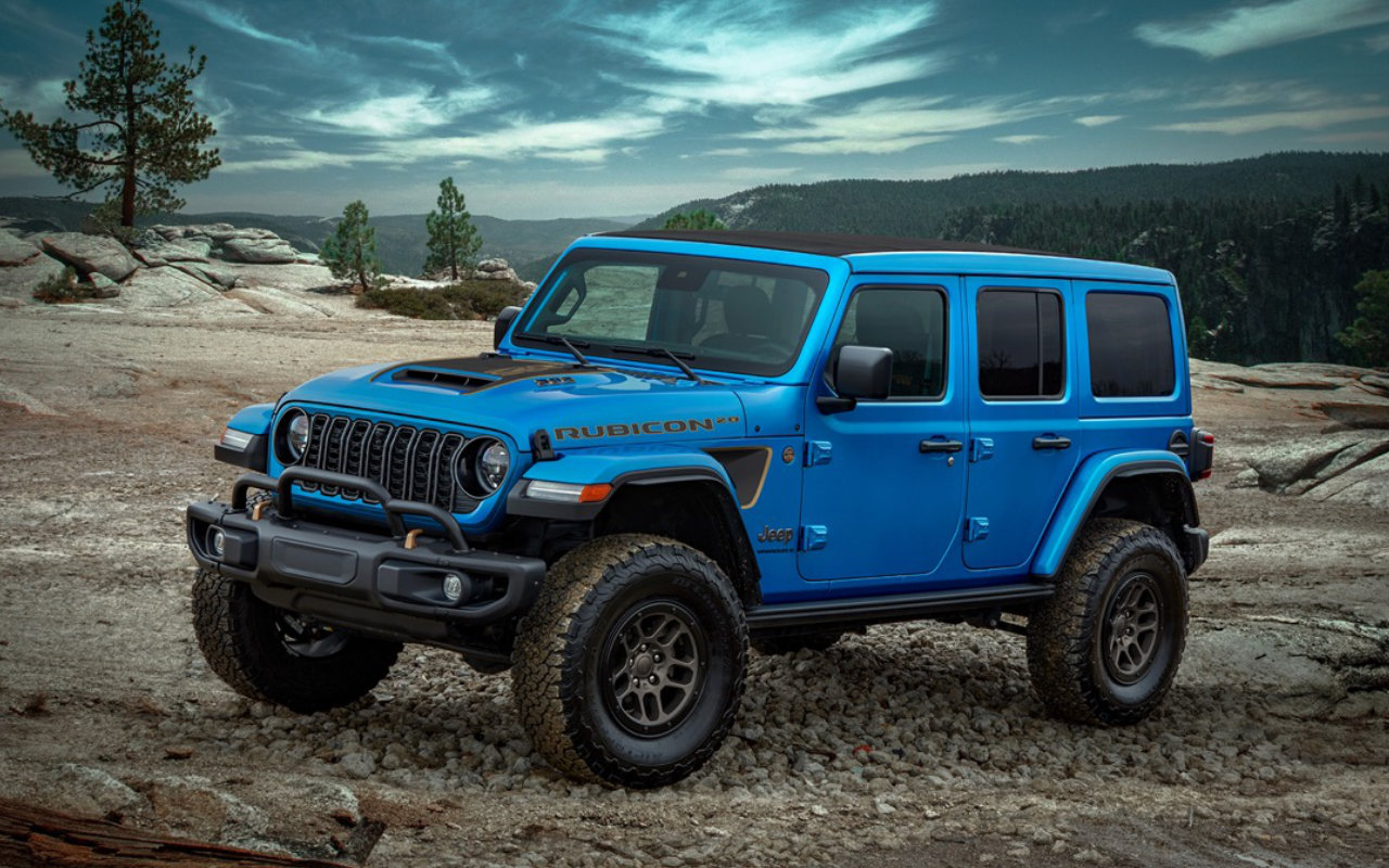 vue latérale avant d'un Jeep Wrangler 4xe 2023 en montagne