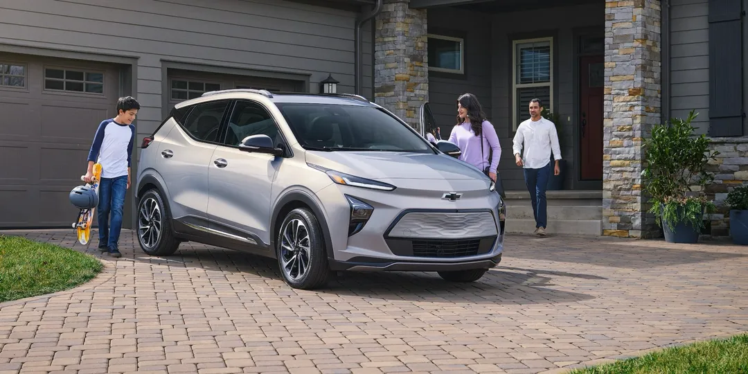 Le Chevrolet Bolt EUV devant une maison.