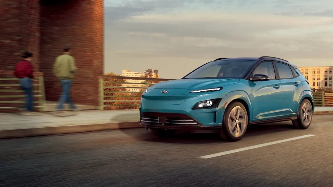 Vue 3/4 avant du Hyundai Kona électrique roulant sur une route.