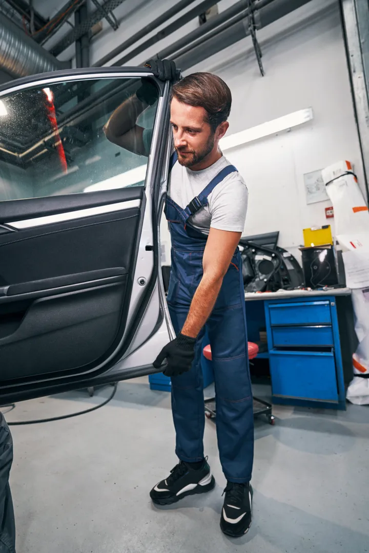 Homme à l'entretien de la portière d'une voiture.