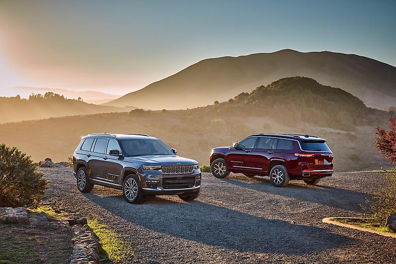 vue de deux Jeep Grand Cherokee 2023 devant des montagnes au crépuscule