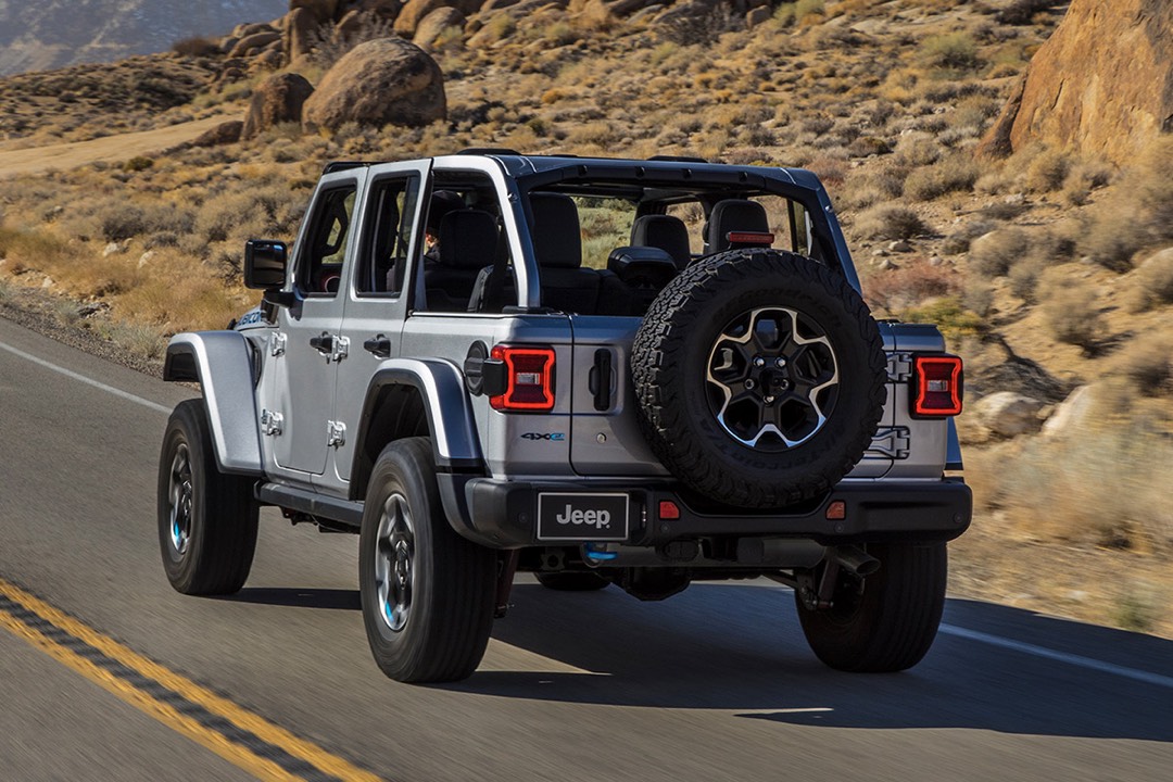 vue latérale arrière d'un Jeep Wrangler 4xe 2023 sur une route en campagne