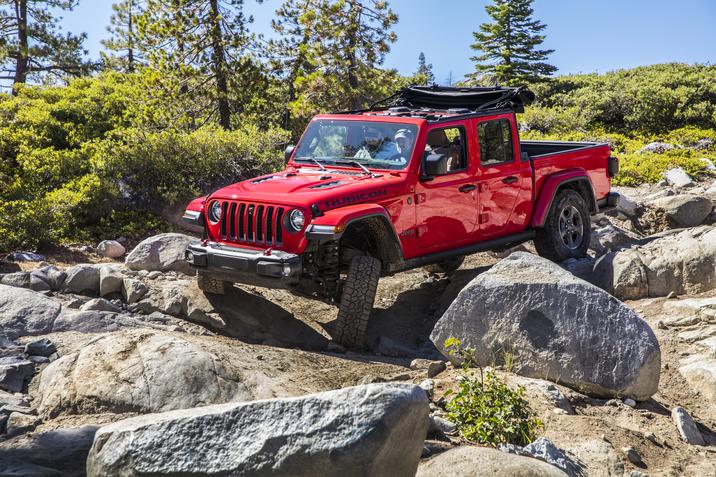 vue latérale avant du Jeep Gladiator 2019 roulant sur un sentier hors piste de rocher