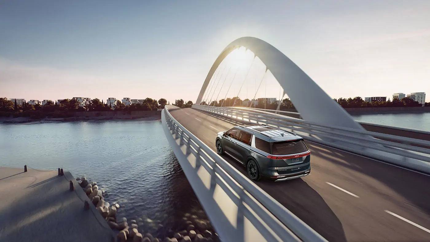 vue latérale arrière d'une Kia Carnival 2023 sur un pont