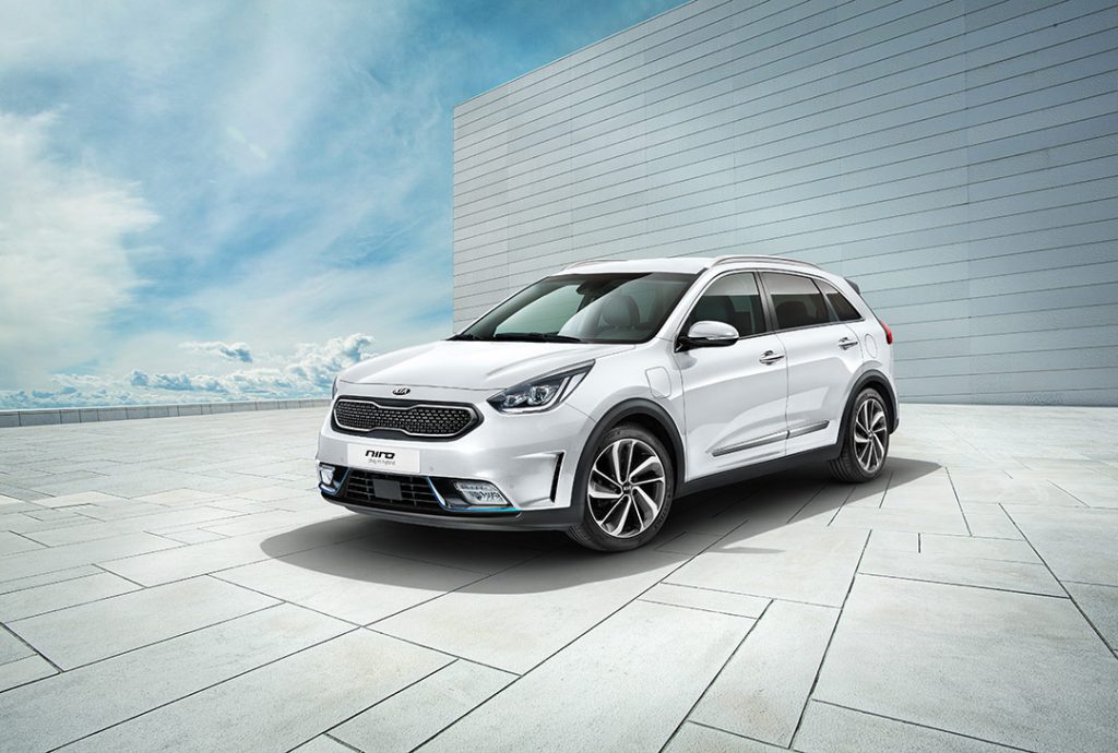 vue trois quart avant du Kia Niro PHEV 2021 stationé proche d'une structure