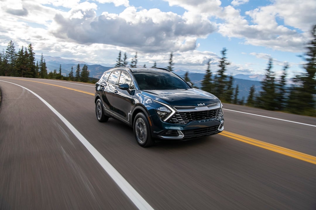 vue trois quart avant du Kia Sportage hybride 2023 sur une route