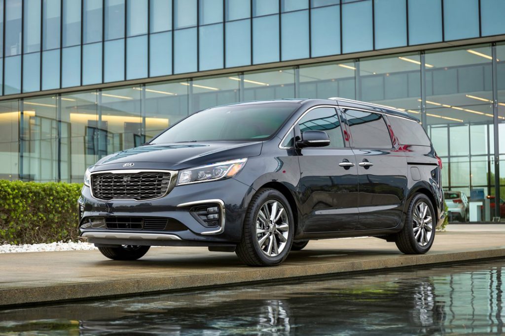 vue latérale avant du Kia Sedona 2021 stationé proche d'un bâtiment