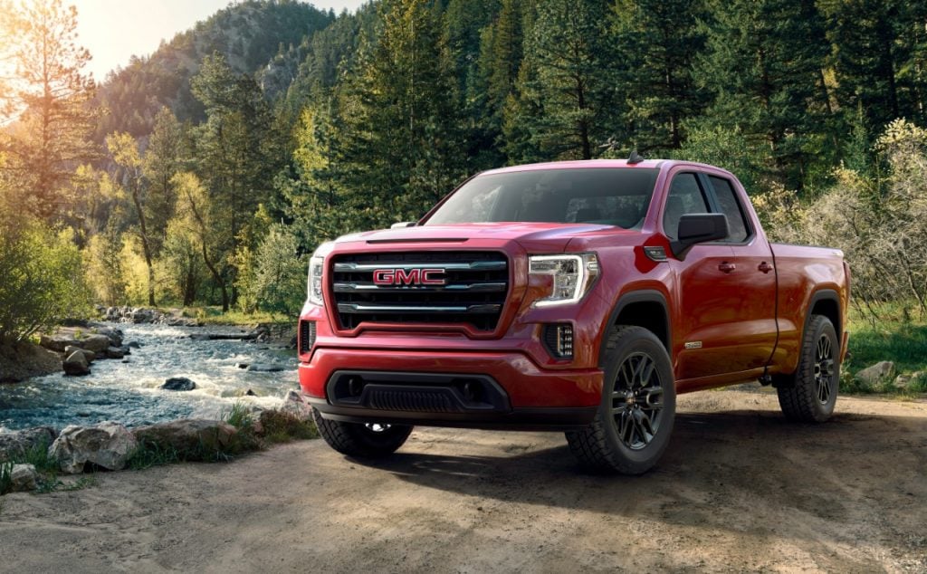 GMC Sierra Elevation 2019 rouge garé dans une forêt avec un ruisseau