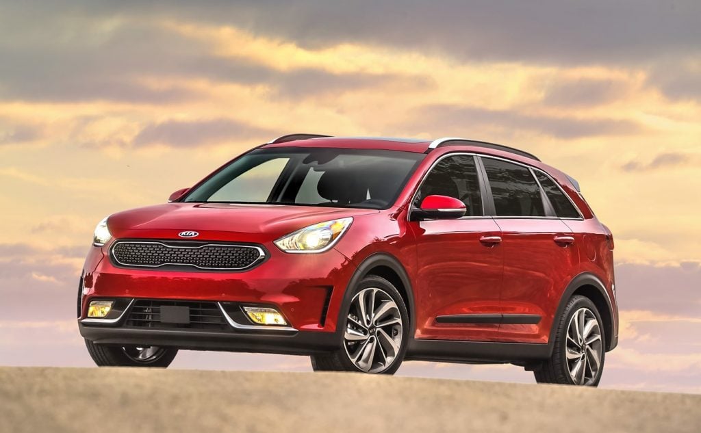 Kia Niro Touring 2017 rouge garé à l'extérieur sous un ciel nuageux