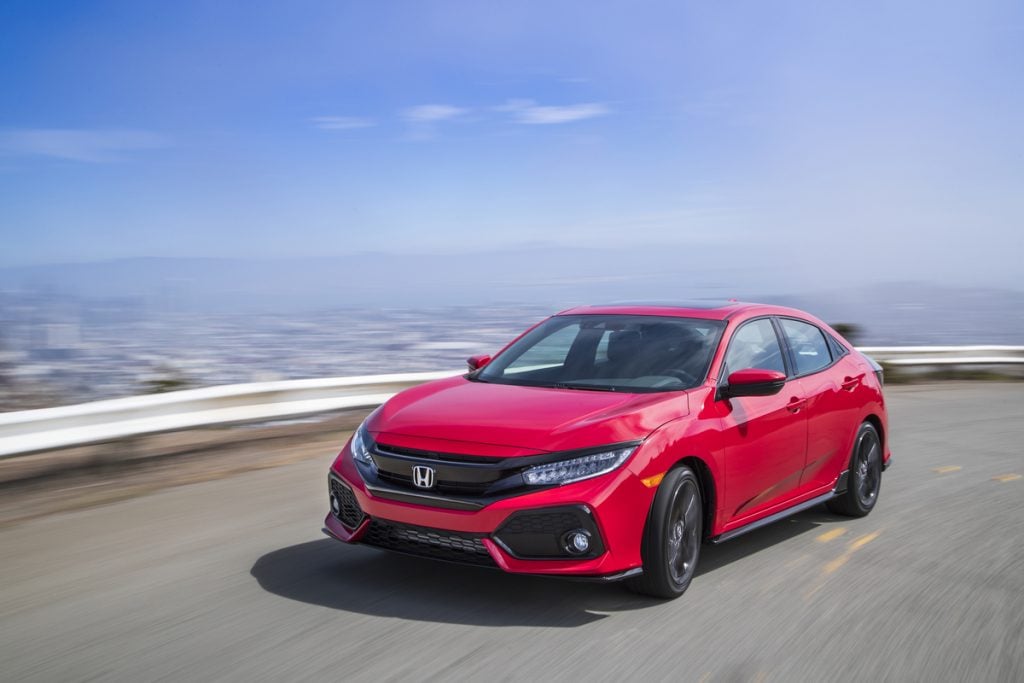 Honda Civic Hatchback 2017 rouge effectuant un virage sur l'autoroute