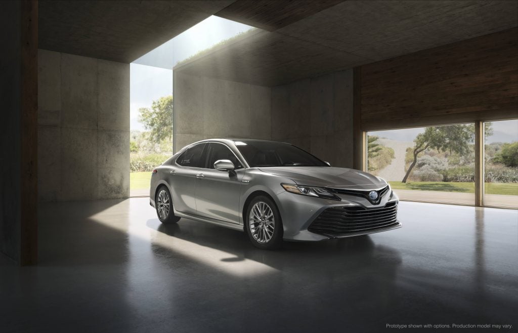 Toyota Camry hybrid XLE 2017 grise garée dans une maison vide, la lumière d'extérieur reflétant sur le véhicule pas les fenêtres